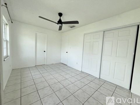 A room with a ceiling fan and tiled floor.
