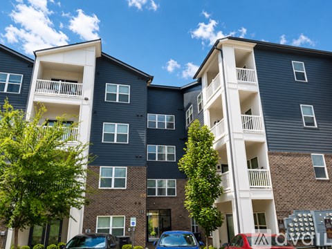 A modern apartment building with balconies and a clear blue sky above.
