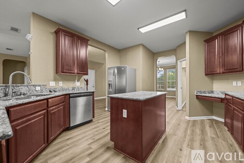 A kitchen with brown cabinets and a refrigerator.