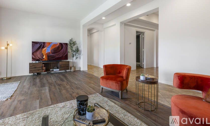 A living room with a red chair and a fireplace.