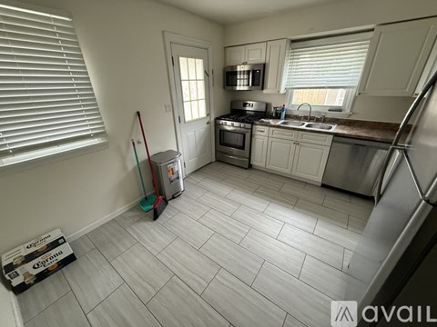 A kitchen with white cabinets and a tile floor.
