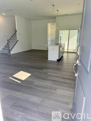 A spacious living room with a grey floor and white walls.