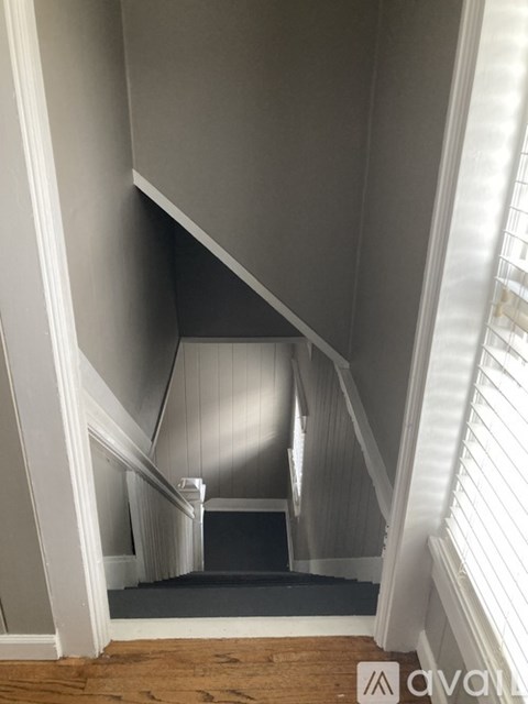 A staircase with a wooden floor and white railings.