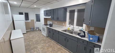 A kitchen with a white refrigerator and a counter with a sink.