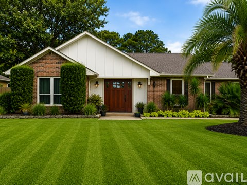 A house with a brown door and green bushes in front.