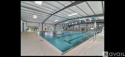 A large indoor swimming pool with a white ceiling and blue water.