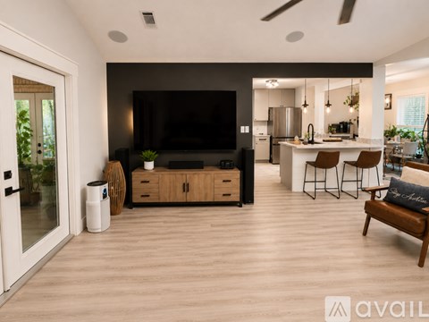 A modern living room with a flat screen TV and a wooden cabinet.
