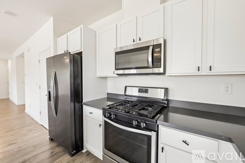 A kitchen with white cabinets and stainless steel appliances.