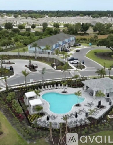 A pool surrounded by a patio area with chairs and a gazebo.