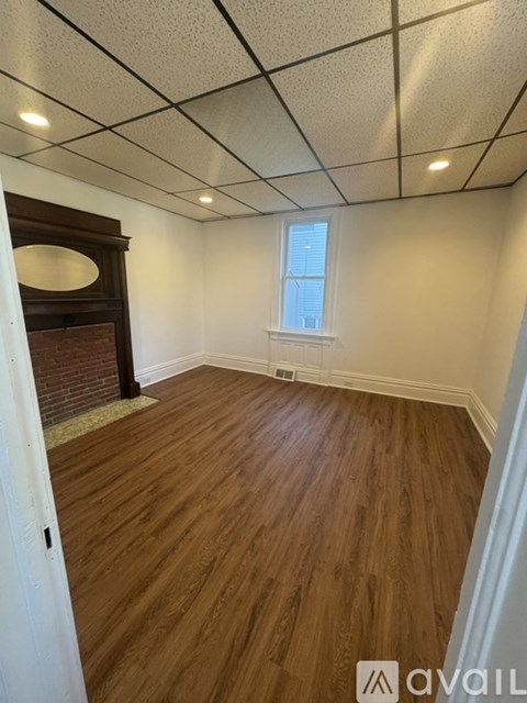 A room with wooden flooring and a window.