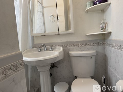 A white sink and toilet in a bathroom with a mirror above it.
