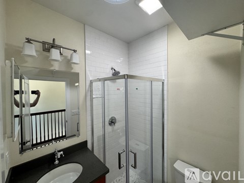 A bathroom with a sink, mirror, and shower.