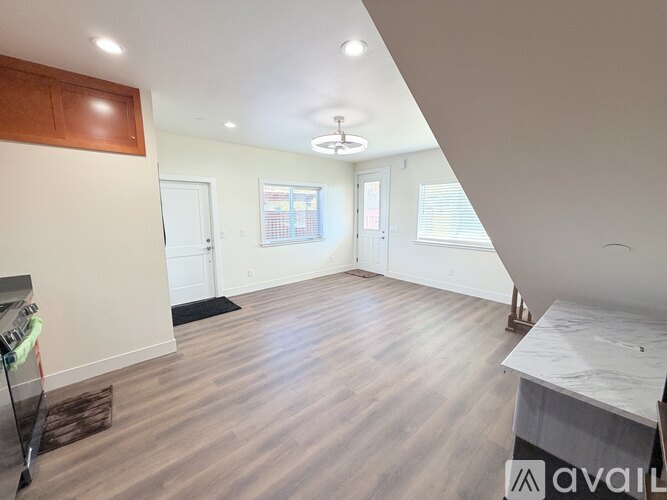 A spacious room with wooden flooring and a white countertop.