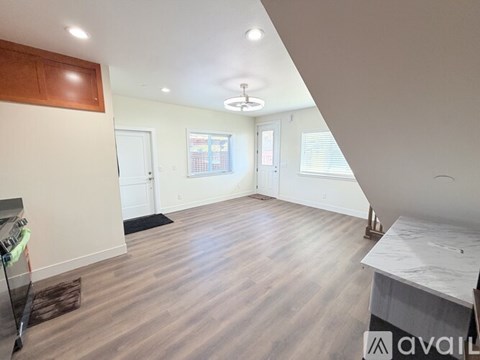 A spacious room with wooden flooring and a white countertop.