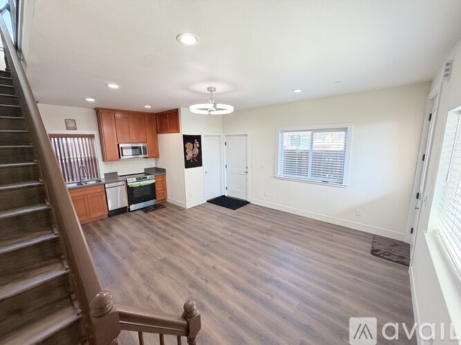 A spacious living room with hardwood floors and a staircase leading to the upper level.