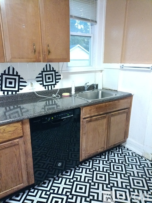 A kitchen with a black and white patterned floor.