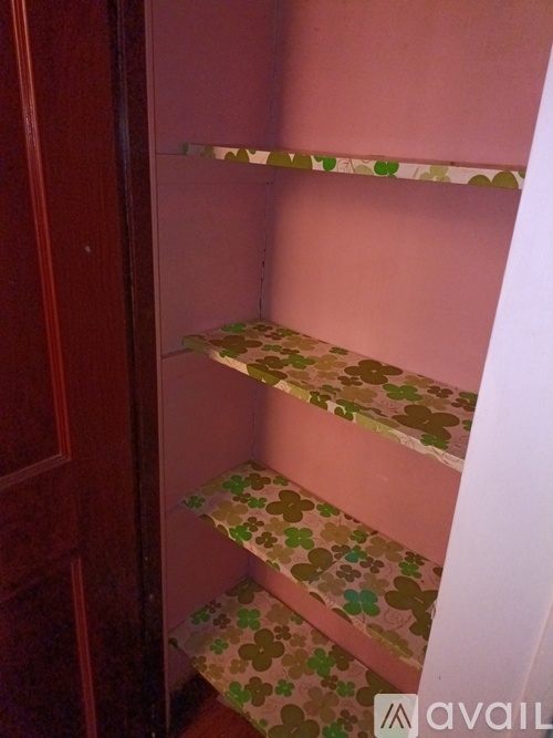 A staircase with a pink wall and a green and brown patterned runner.