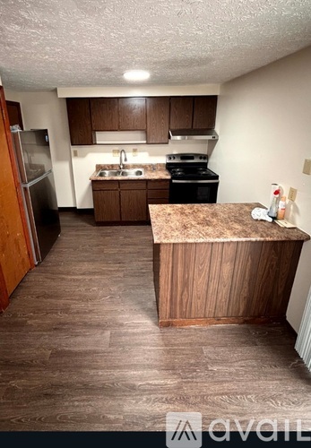 A kitchen with a refrigerator, stove, and sink.