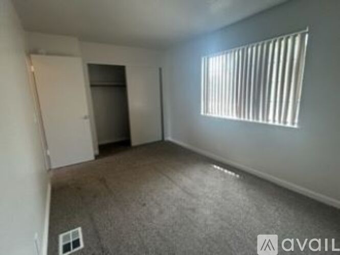 A room with a window and a door is available for rent.