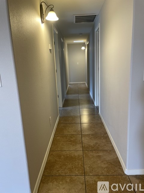 A long hallway with tiled floors and white walls.
