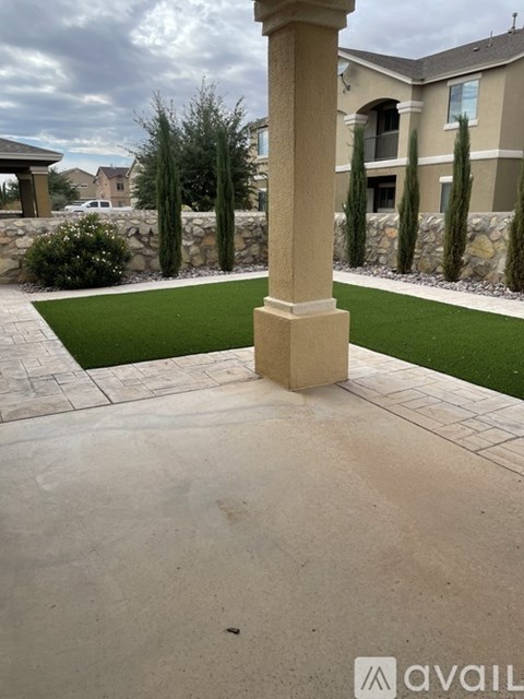 A concrete pillar stands in the middle of a concrete walkway.