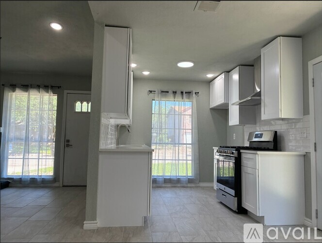 A kitchen with white cabinets and appliances is available for rent.