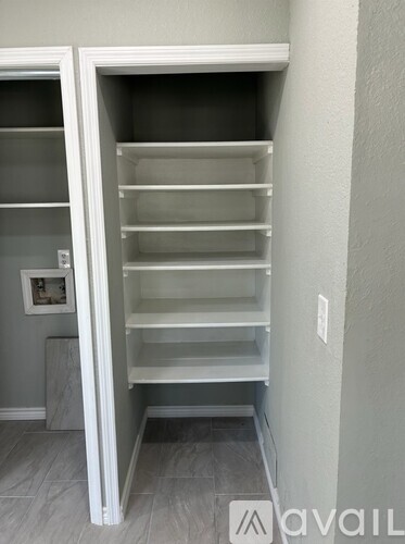 A white pantry with shelves and a door.