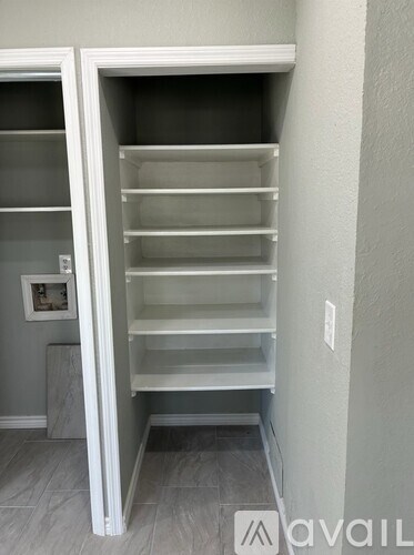 A white pantry with shelves and a door.