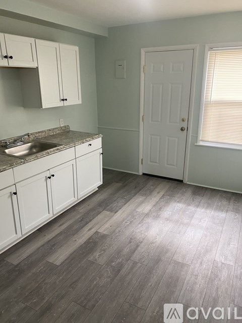 A kitchen with white cabinets and a sink.