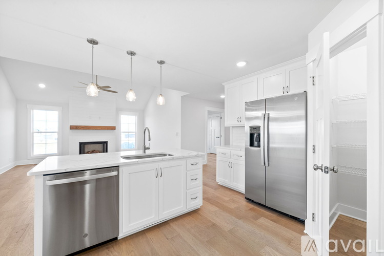 A modern kitchen with white cabinets and stainless steel appliances.