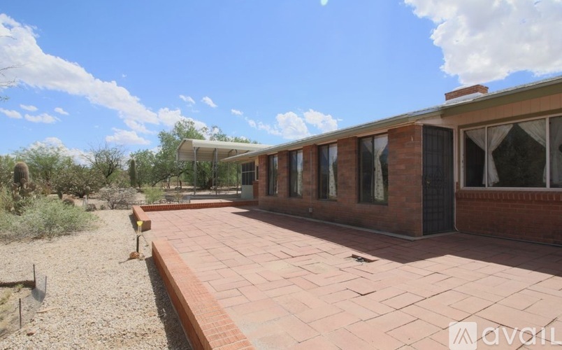 A brick building with a balcony and a small garden in front.