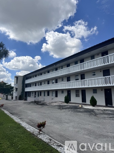 A large white building with a balcony on the second floor.