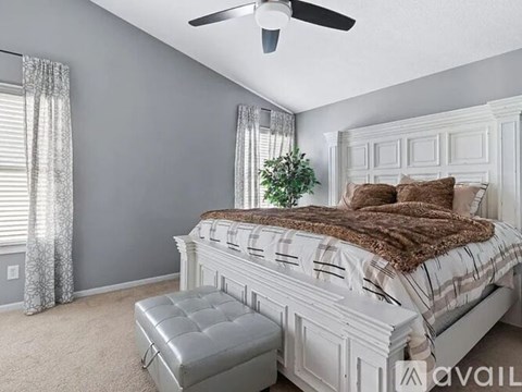 A bedroom with a large bed and a ceiling fan.