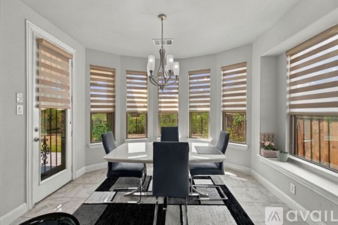 A dining room with a table and chairs and a chandelier.