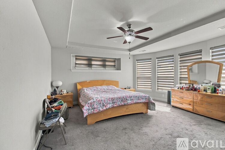 A bedroom with a bed, dresser, and chair.
