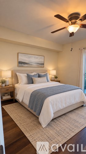A bedroom with a bed, nightstands, and a ceiling fan.