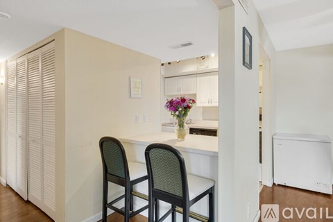A kitchen with a table and chairs.