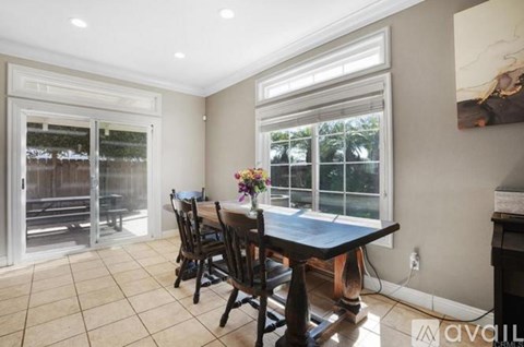 A dining room with a table and chairs.