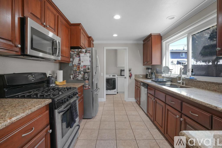 A kitchen with brown cabinets and a black stove top oven.