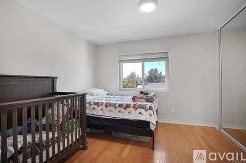 A bedroom with a bed and a crib.
