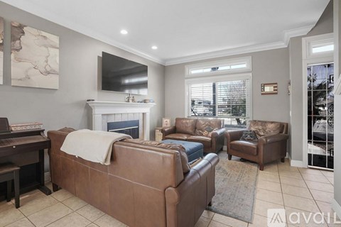 A living room with a brown couch and a fireplace.