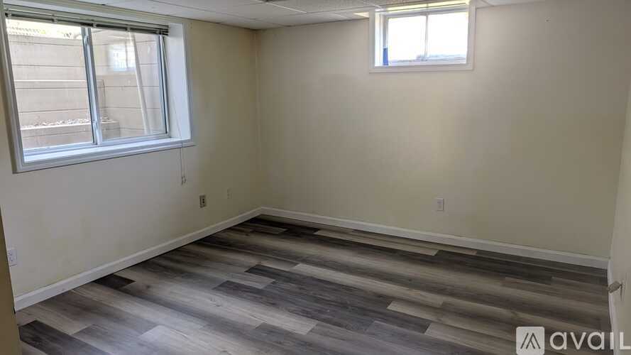 A room with a window and a wooden floor.
