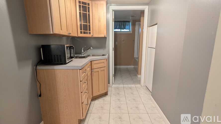 A kitchen with wooden cabinets and a black microwave.