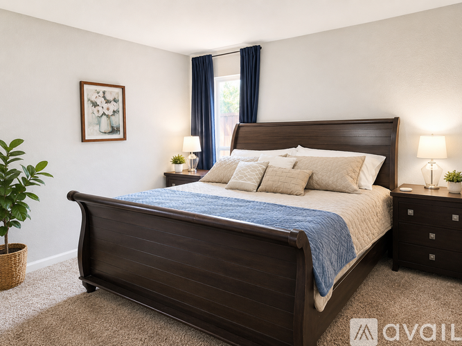 A bedroom with a large bed and a plant.