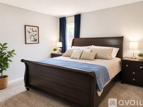 A bedroom with a large bed and a plant.