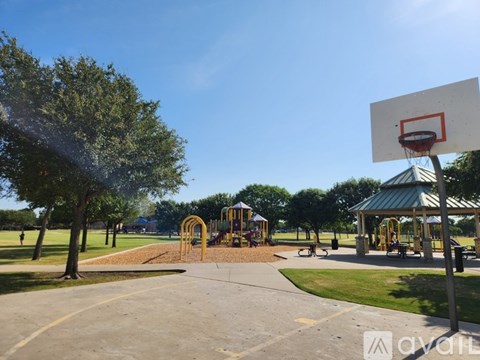 A basketball court with a hoop and a playground with swings and slides.