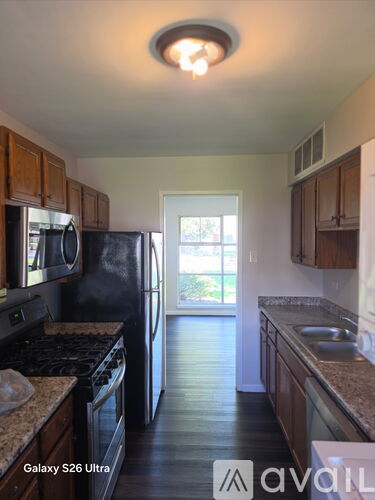 A kitchen with a refrigerator, microwave, and oven.