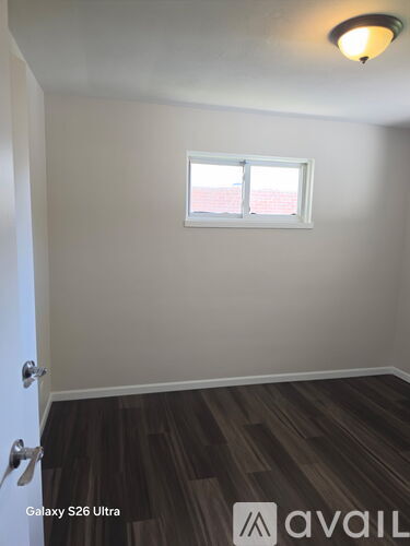 A room with a door and a window with a white frame.