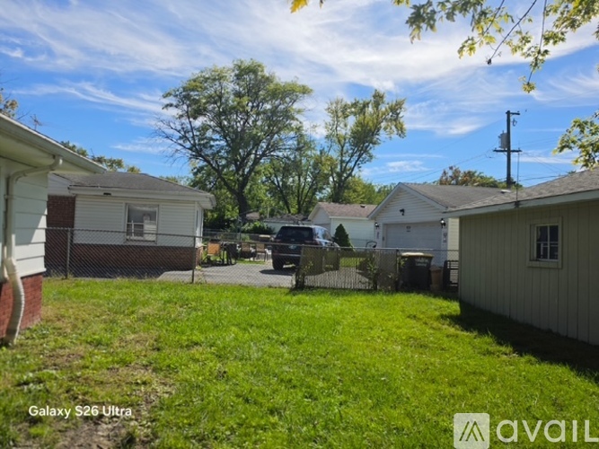 A backyard with a fence and a tree.
