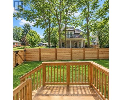 A wooden deck with a house in the background.